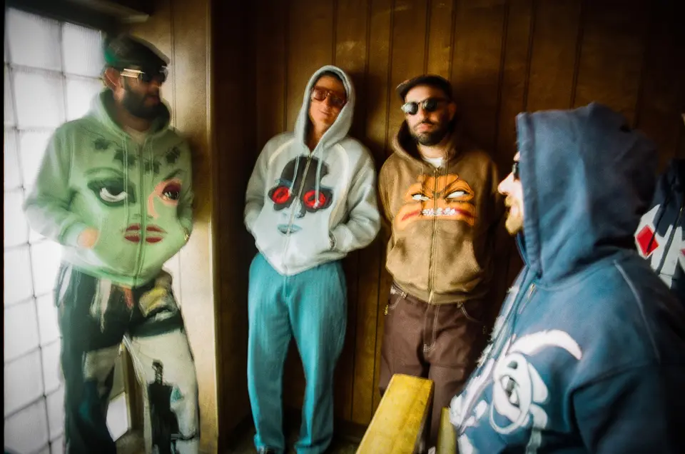 Group in villain face hoodies in a wood-panelled hallway