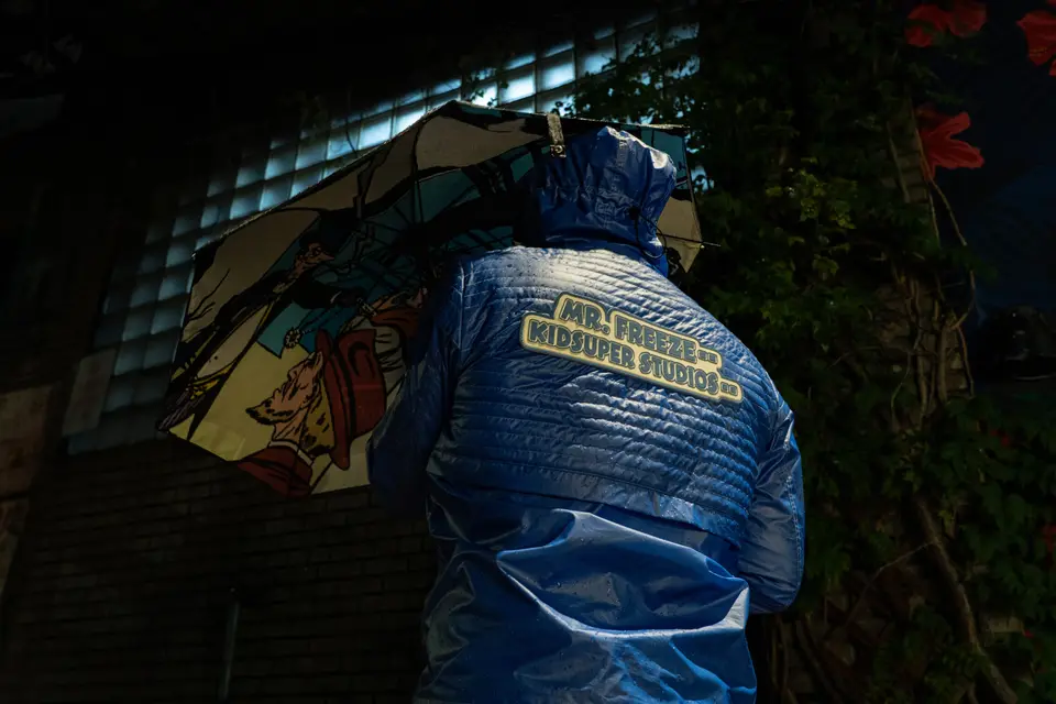 Back of the Mr. Freeze puffer under a comic-print umbrella at night
