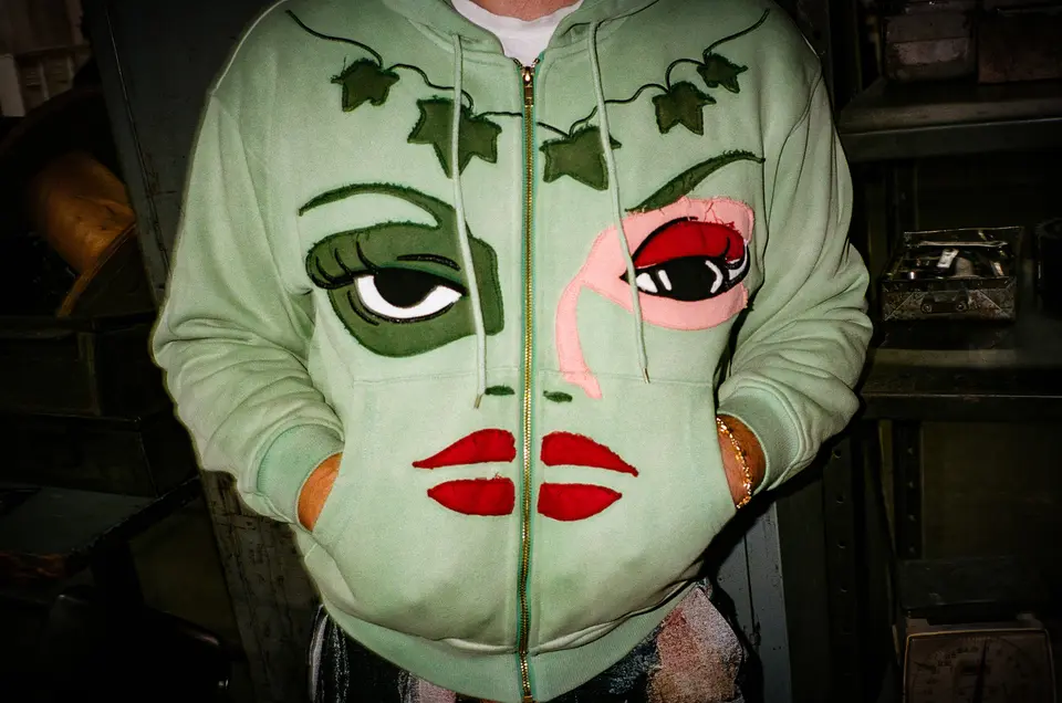 Close-up of the green Poison Ivy face hoodie with ivy leaves and red lips